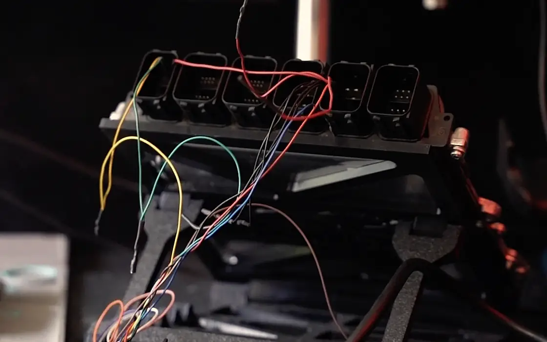 An ECU wired up on the bench frame, ready for a read