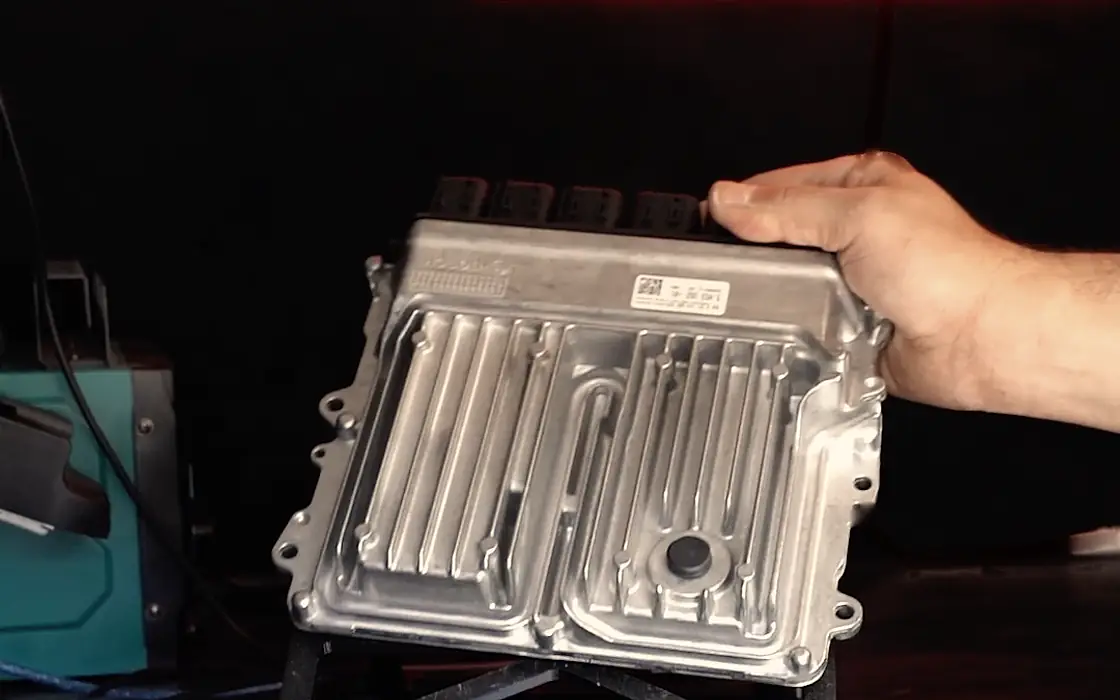 An ECU set down on the bench under the Platinum Tune neon